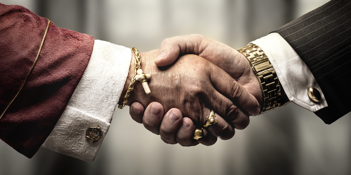 Poignée de main entre symboles religieux et financiers
